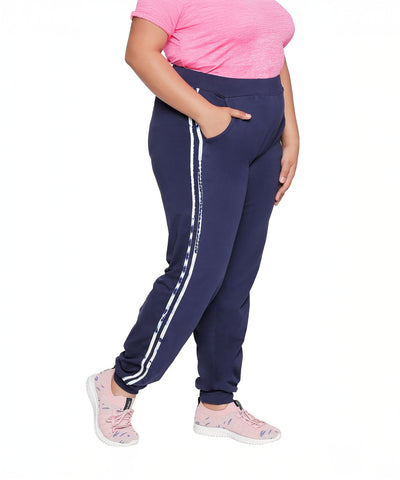 Person wearing plus-size navy joggers with side stripe, a pink t-shirt, and light pink sneakers.