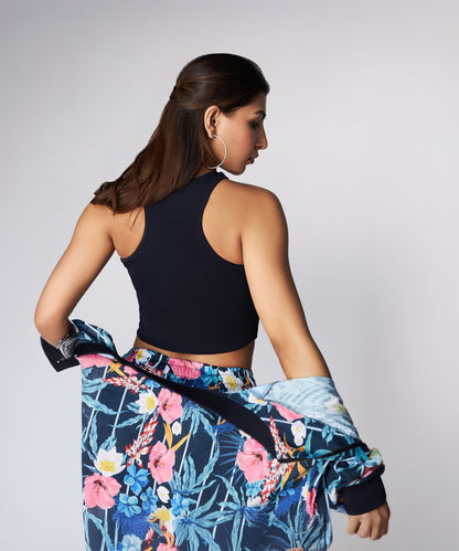 Woman facing away, wearing a Navy Blue Crop Top and floral pants, holding a matching floral jacket.