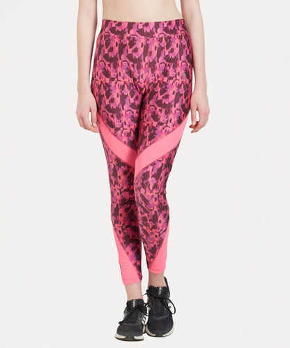 A woman models the Printed Slim Fit Track Pant LUSH, featuring a pink print and high-rise waistband, paired with black sneakers against a white background.