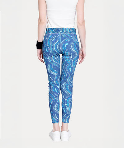 Person wearing Tuna Active Printed Blue Leggings, a white top, white shoes, and a black wristband, shown from the back.