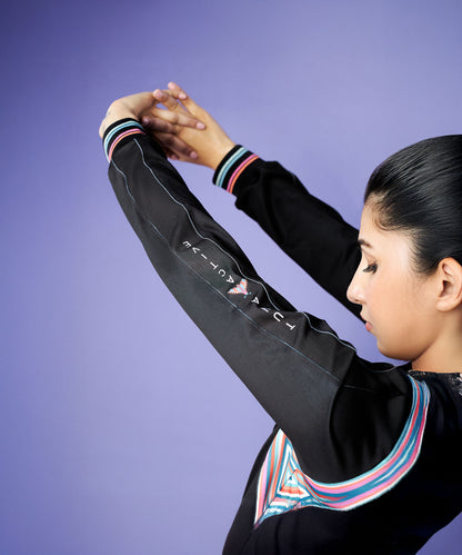 Woman stretching her arms overhead, wearing the Tuna Active Black Bomber Jacket with colored stripes, against a purple background.