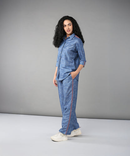 Woman models the Denim Linen Co-Ord Set—a high-quality denim ensemble with a relaxed fit shirt and red piping—posing in a studio with a gray backdrop.