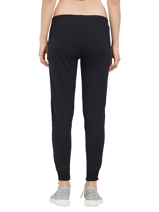 Person seen from the back wearing Classic Joggers TLC02SS—black joggers with a drawstring closure—paired with gray sneakers, set against a white background. An essential addition to any casual wardrobe.