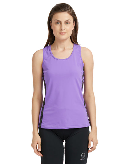 A woman stands against a white background wearing a Purple round neck sleeveless top with moisture-wicking properties and black leggings.