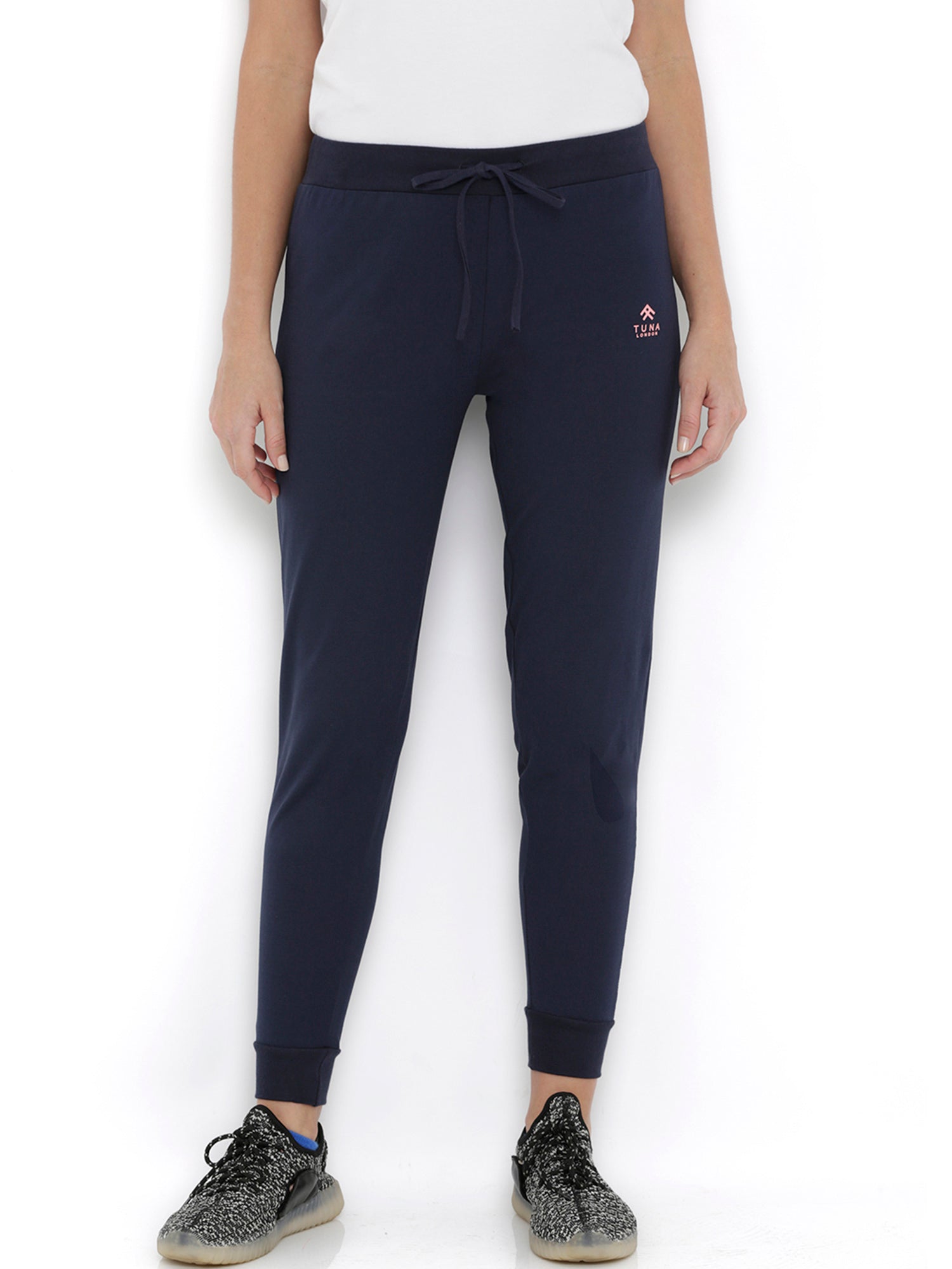 Wearing Blue Classic Joggers TLC04 with adjustable fit, a white t-shirt, and black sneakers, standing against a white background—ideal for stylish lounging.